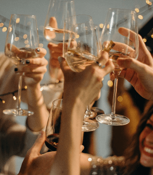 Leute stoßen mit Weingläsern an.